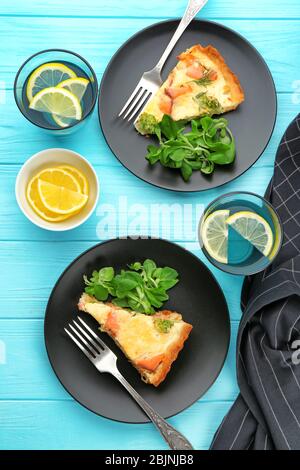 Teller mit Stücken Lachs Quiche Pie auf dem Tisch Stockfoto