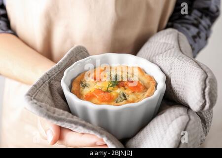Frau, die Ramekin mit schmackhaftem Lachskartellet hält Stockfoto