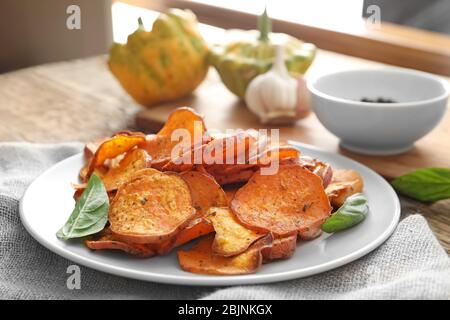 Mit leckeren Süßkartoffel-Chips auf der Tischplatte Stockfoto