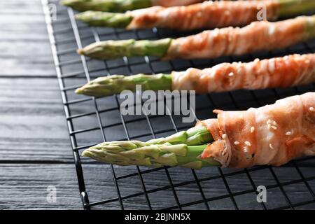 Teller mit Speck umwickelt Spargel auf hellem Hintergrund Stockfoto