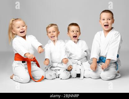 Kleine Kinder in Karategi auf hellem Hintergrund Stockfoto