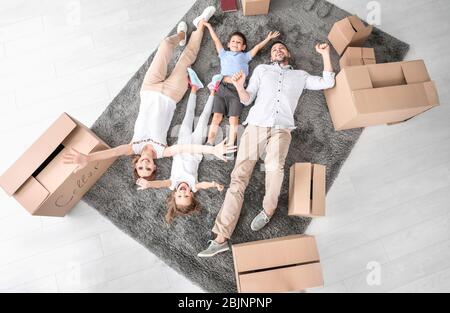 Müde Familie liegt auf dem Boden in neuer Wohnung. Move House Konzept Stockfoto