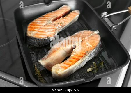 Grillpfanne mit köstlichen Lachssteaks auf dem Herd in der Küche Stockfoto