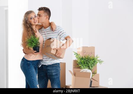 Junges Paar mit Kisten im Zimmer im neuen Zuhause Stockfoto