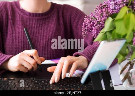 Graphic Designer Retucher Freelancer arbeitet von zu Hause aus. Frau nutzt Grafik-Tablet in gemütlichen Home Office mit Laptop, Computer. Remote-Arbeit. Blogger Stockfoto