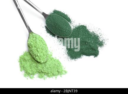 Löffel mit Weizengras und Spirulina Pulver auf weißem Hintergrund Stockfoto
