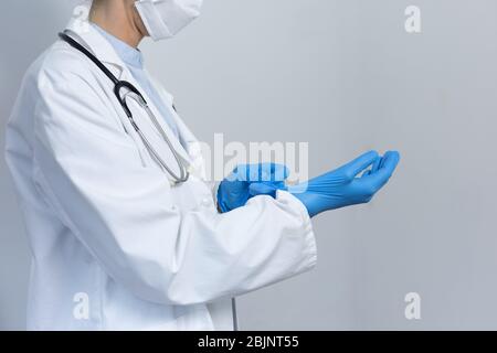 Medizinisches Personal, das während der Coronavirus Covid19-Pandemie blaue Handschuhe und Gesichtsmaske trägt Stockfoto