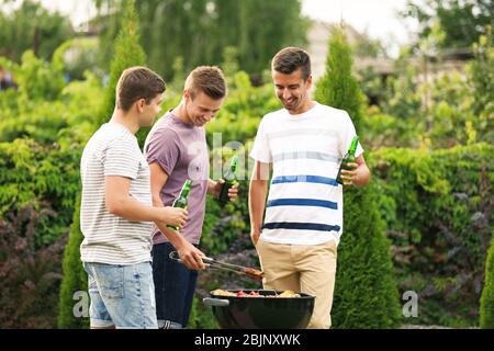 Männer kochen leckeres Essen auf dem Grill, im Freien Stockfoto