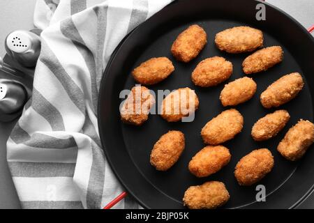 Bratpfanne mit Lachs-Kroketten auf dem Tisch Stockfoto