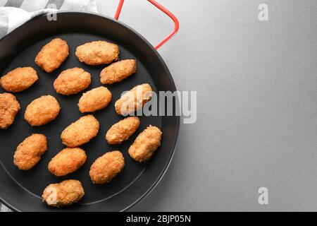 Bratpfanne mit Lachs-Kroketten auf dem Tisch Stockfoto