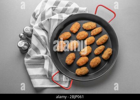 Bratpfanne mit Lachs-Kroketten auf dem Tisch Stockfoto