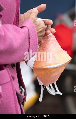 Dresden, Deutschland. April 2020. Eine Frau verkauft selbstgenähte Mundschutz auf einem Wochenmarkt für jeweils 6.50 Euro. In Sachsen wurden die Lebensbeschränkungen im Kampf gegen die Corona-Pandemie vorsichtig gelockert, im Einzelhandel sind aber Masken Pflicht. Quelle: Sebastian Kahnert/dpa-Zentralbild/dpa/Alamy Live News Stockfoto