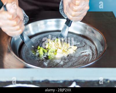 Herstellung von Eisrollen. Man Hände machen Kiwi und Banane Thay Stil natürliches Eis Stockfoto