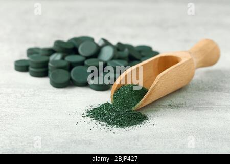 Holzkelle mit Spirulina Pulver auf dem Tisch Stockfoto