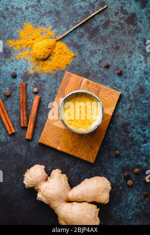Draufsicht auf Kurkuma Latte, die aus Curcuma, Ingwer, Zimt und Piment hergestellt wird. Immun- und Gesundheitstrunk. Stockfoto