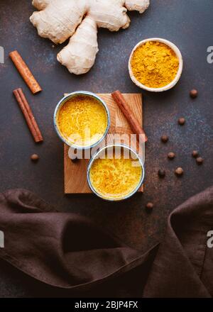Draufsicht auf Kurkuma Latte, die aus Curcuma, Ingwer, Zimt und Piment hergestellt wird. Immun- und Gesundheitstrunk. Stockfoto
