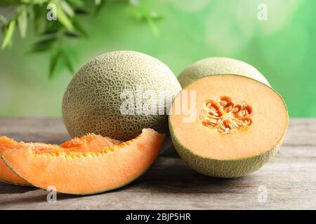 Frische reife Melonen auf Holztisch im Freien Stockfoto