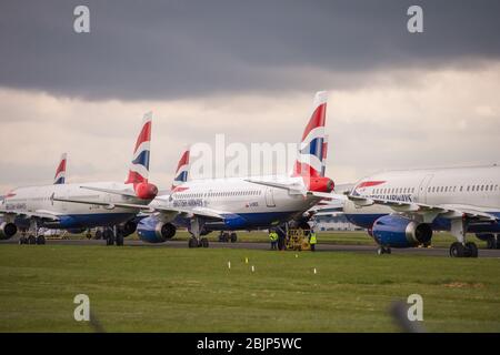 Glasgow, Großbritannien. April 2020. Im Bild: Gewitterwolken sammeln sich, als die Bodencrews von British Airways die Sammlung von 14 geerdeten Flugzeugen des Typs Airbus A319/A320 & A321 in Betrieb nehmen, die seit Beginn der Sperrung des Coronavirus (COVID-19) auf der zweiten Start- und Landebahn des Flughafens Glasgow geparkt wurden. Die globale Luftfahrtindustrie ist seitdem in eine Kernschmelze geritten, einige Fluggesellschaften gehen in die Pleite und andere wie BA bitten um staatliche finanzielle Unterstützung. Bis heute hat BA angekündigt, dass es fast 12,000 Mitarbeiter zu nehmen. Quelle: Colin Fisher/Alamy Live News Stockfoto