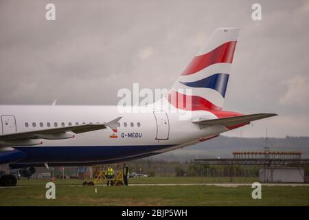 Glasgow, Großbritannien. April 2020. Im Bild: Gewitterwolken sammeln sich, als die Bodencrews von British Airways die Sammlung von 14 geerdeten Flugzeugen des Typs Airbus A319/A320 & A321 in Betrieb nehmen, die seit Beginn der Sperrung des Coronavirus (COVID-19) auf der zweiten Start- und Landebahn des Flughafens Glasgow geparkt wurden. Die globale Luftfahrtindustrie ist seitdem in eine Kernschmelze geritten, einige Fluggesellschaften gehen in die Pleite und andere wie BA bitten um staatliche finanzielle Unterstützung. Bis heute hat BA angekündigt, dass es fast 12,000 Mitarbeiter zu nehmen. Quelle: Colin Fisher/Alamy Live News Stockfoto