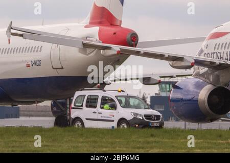 Glasgow, Großbritannien. April 2020. Im Bild: Gewitterwolken sammeln sich, als die Bodencrews von British Airways die Sammlung von 14 geerdeten Flugzeugen des Typs Airbus A319/A320 & A321 in Betrieb nehmen, die seit Beginn der Sperrung des Coronavirus (COVID-19) auf der zweiten Start- und Landebahn des Flughafens Glasgow geparkt wurden. Die globale Luftfahrtindustrie ist seitdem in eine Kernschmelze geritten, einige Fluggesellschaften gehen in die Pleite und andere wie BA bitten um staatliche finanzielle Unterstützung. Bis heute hat BA angekündigt, dass es fast 12,000 Mitarbeiter zu nehmen. Quelle: Colin Fisher/Alamy Live News Stockfoto