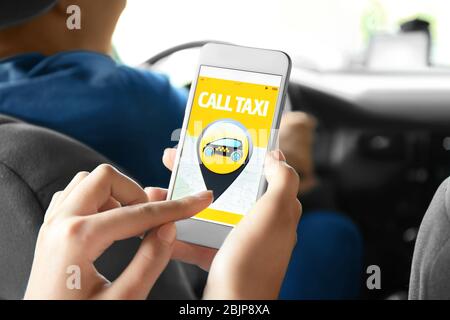 Junge Frau mit Handy im Taxi Stockfoto