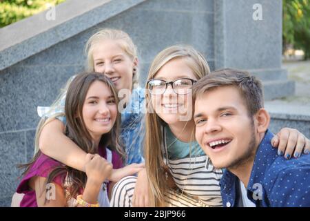 Glückliche Teenager sitzen draußen auf Steintreppen Stockfoto