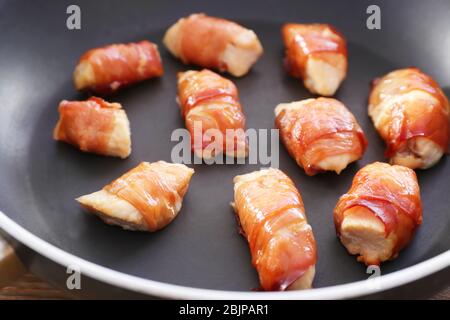 Speck umwickelt Huhn in Bratpfanne, Nahaufnahme Stockfoto