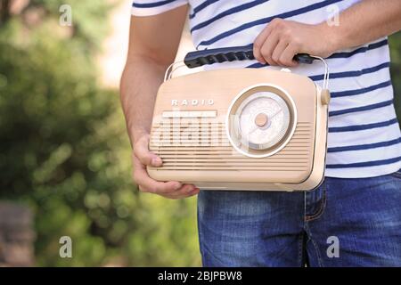 Junger Mann mit Retro-Radio im Freien Stockfoto