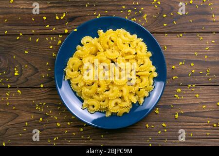 Pene Lisce Pasta in blauer Platte auf dunklem Holzhintergrund. Von oben Stockfoto