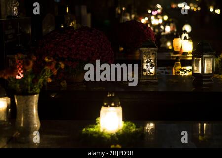 Kerzen auf Gräbern auf dem Rakowicki Friedhof in Krakau bei Nacht, Polen im Jahr 2019. Stockfoto