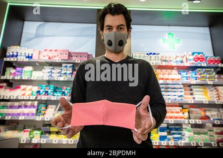 Paris, Frankreich. April 2020. Ein Mitarbeiter zeigt eine Stoffmaske in einer Apotheke in Paris, Frankreich, am 29. April 2020. Die Zahl der Todesopfer des Coronavirus stieg auf 24,087, während die Krankenhausaufenthalte und Patienten auf der Intensivstation am Mittwoch weiter zurückgingen. Kredit: Aurelien Morissard/Xinhua/Alamy Live News Stockfoto