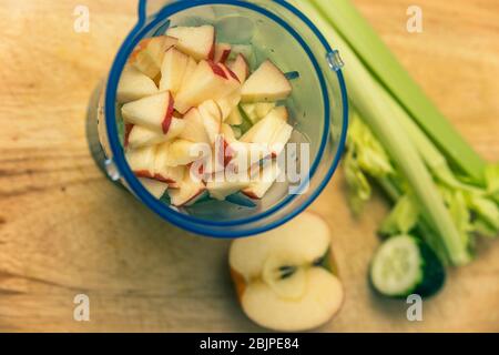 Gesunde Zutaten für die Herstellung eines grünen Smoothie im Mixer zu Hause mit Apfel, Gurke, Sellerie und Zitrone Stockfoto