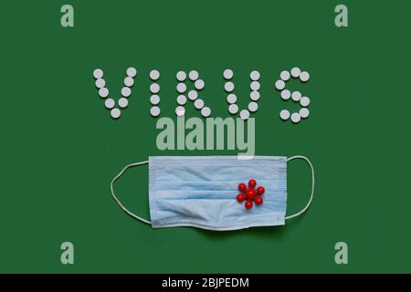 VIRUS Inschrift aus weißen Pillen auf schwarzem Hintergrund mit einer medizinischen Maske Stockfoto