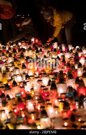 Mädchen stellen Kerzen vor dem Denkmal für die polnischen Opfer des Kommunismus auf dem Rakowicki Friedhof in Krakau, Polen 2019. Stockfoto