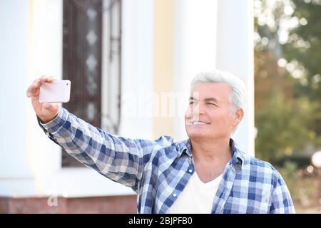 Schöner reifer Mann unter Selfie im Freien Stockfoto