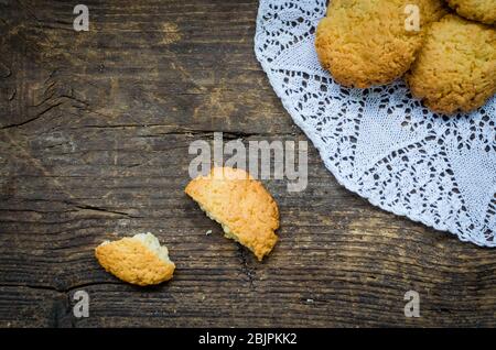 Hausgemachte Kokosnusskekse auf einem dunklen alten Holztisch. Frisch gebackene Kokosnusskeks auf rustikalem Hintergrund. Draufsicht. Stockfoto