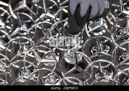 Sindelfingen, Deutschland. April 2020. Ein Mitarbeiter der Daimler AG holt einen Mercedes-Stern aus der Box in der Produktion der S-Klasse. Quelle: Marijan Murat/dpa/Alamy Live News Stockfoto