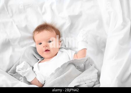 Süße kleine Baby im Bett zu Hause liegen Stockfoto