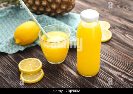 Flasche und Glas frisch gepresster Zitronensaft auf dem Tisch Stockfoto