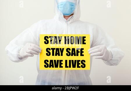 Stay Home Stay Safe Save Lives Text auf gelbem Warnschild in den Händen von Ärzten. Coronavirus, Covid-19 Selbstquarantäne-Isolierung. Medizin, Gesundheitswesen Stockfoto