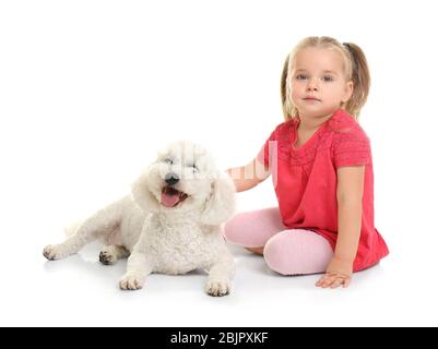 Entzückende kleine Mädchen mit ihrem Hund auf weißem Hintergrund Stockfoto