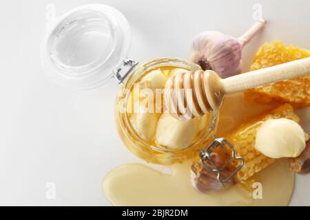 Zusammensetzung mit Honig und Knoblauch als natürliche Kältemittel auf weißem Hintergrund, Draufsicht Stockfoto