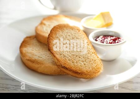 Teller mit frischen knusprigen Toasts auf dem Tisch Stockfoto
