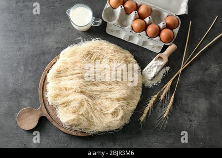 Zerfetzter dünner Teig mit Zutaten auf dem Tisch Stockfoto