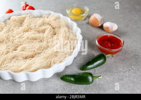 Backform mit zerfetztem dünnen Teig auf dem Tisch Stockfoto