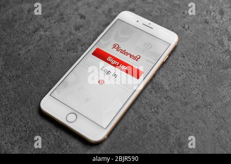 KIEW, UKRAINE - 23. OKTOBER 2017: IPhone 8 Plus Gold mit Pinterest-App auf dem Bildschirm, liegend auf grauem Tisch Stockfoto
