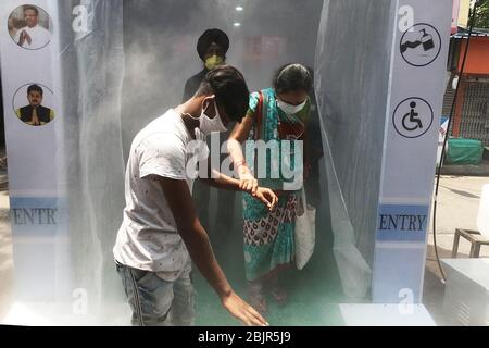 Kalkutta, Indien. April 2020. Die Menschen passieren die von der lokalen Behörde installierte Desinfektionslösung, während sie am 29. April 2020 in Kalkutta, Indien, auf den lokalen Markt kommen. (Foto von Sudipta Pan/ Pacific Press/Sipa USA) Quelle: SIPA USA/Alamy Live News Stockfoto