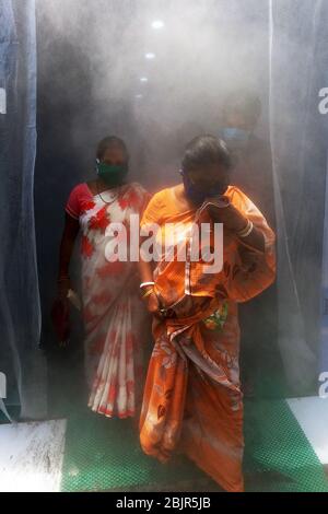 Kalkutta, Indien. April 2020. Die Menschen passieren die von der lokalen Behörde installierte Desinfektionslösung, während sie am 29. April 2020 in Kalkutta, Indien, auf den lokalen Markt kommen. (Foto von Sudipta Pan/ Pacific Press/Sipa USA) Quelle: SIPA USA/Alamy Live News Stockfoto