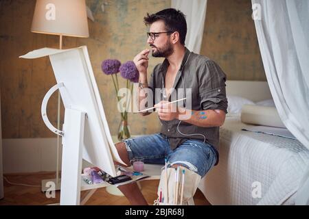 Junger Mann Künstler Malerei mit Öl auf Leinwand. Stockfoto