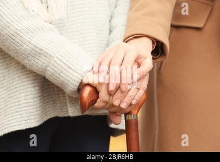 Junge Pflegekraft Unterstützung ältere Frau mit Stock, Nahaufnahme Stockfoto